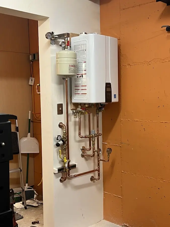 Plumbing technician inspecting water heater connections in Williston